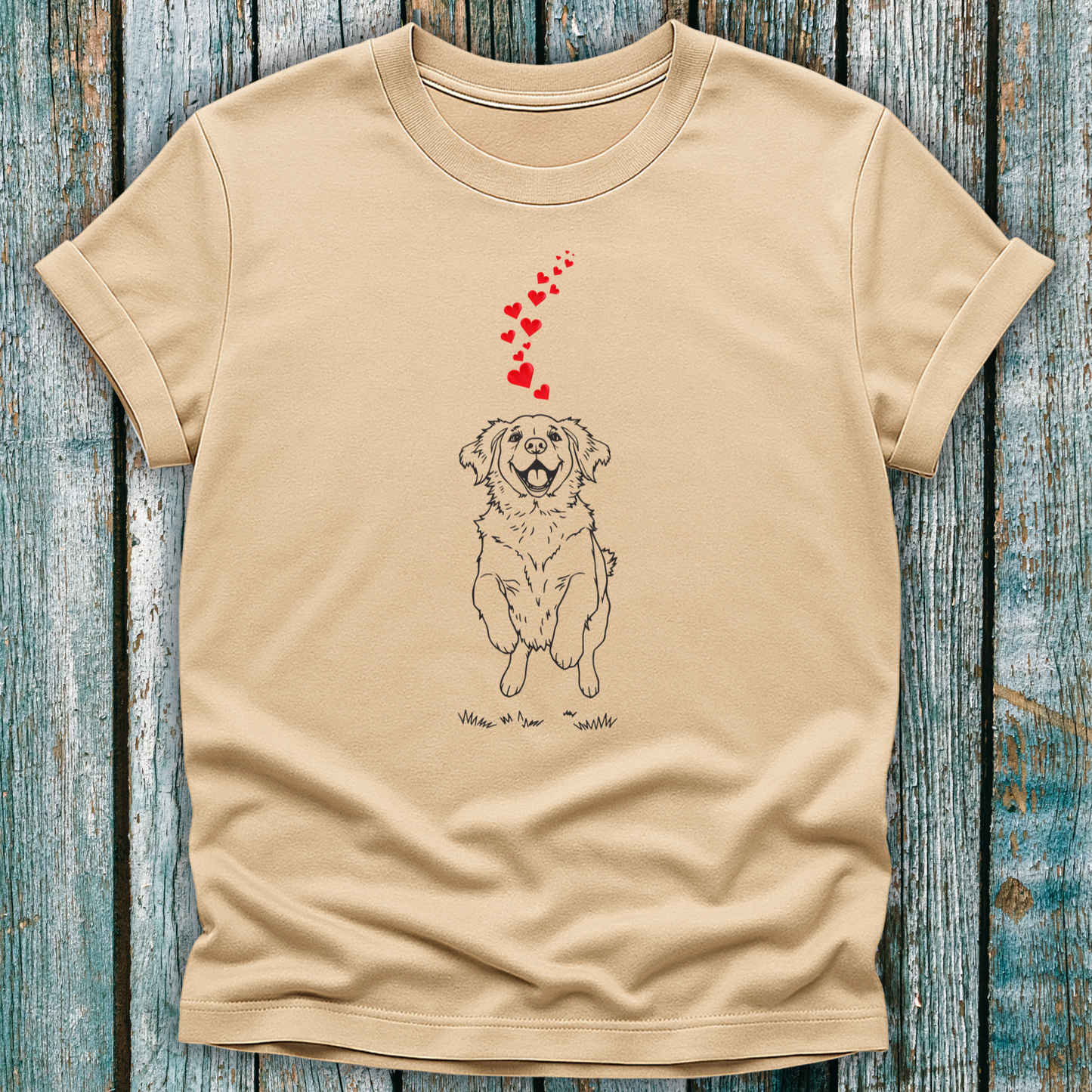 Beige t-shirt with a dog graphic and red hearts on a wooden surface