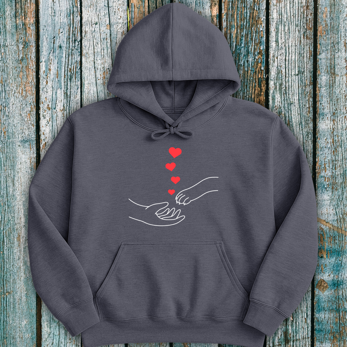 Gray hoodie with a design of hands holding paws and hearts on a wooden surface