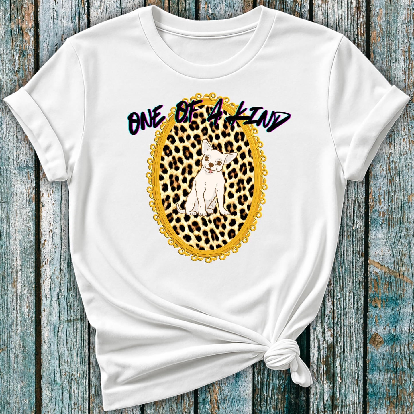 White t-shirt with a graphic of a Chihuahua dog in a leopard print frame and 'One of a Kind' text on a wooden surface.
