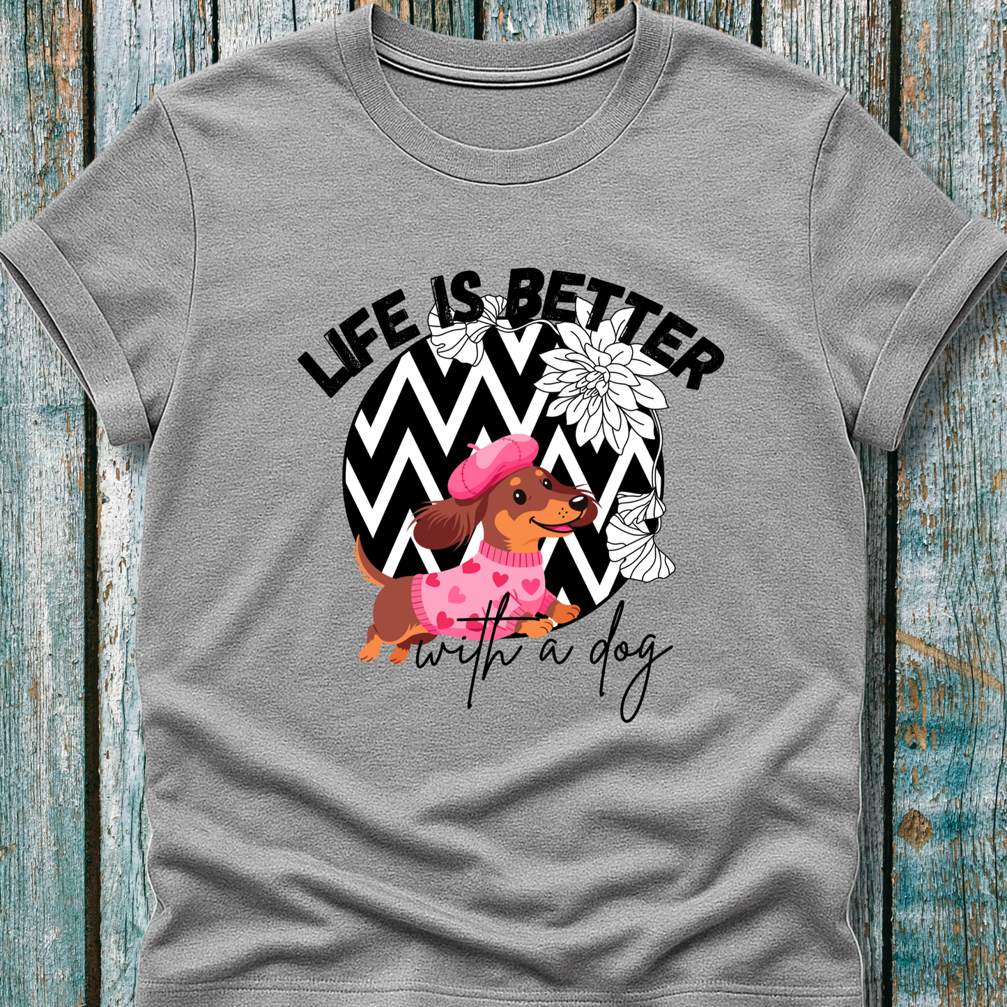 Gray t-shirt with a dog graphic and 'Life is better with a dog' text on a wooden surface