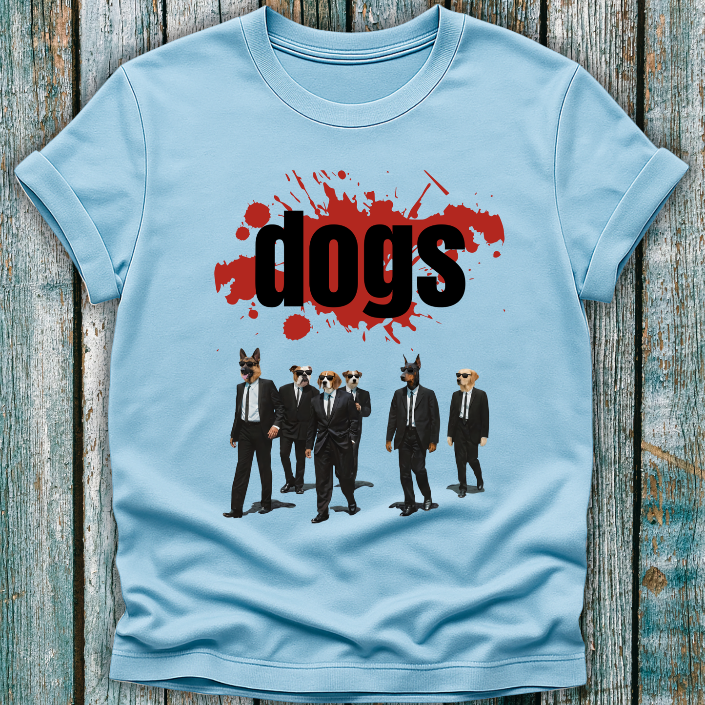 Light blue t-shirt with graphic design of dogs in suits and 'dogs' text on a wooden surface