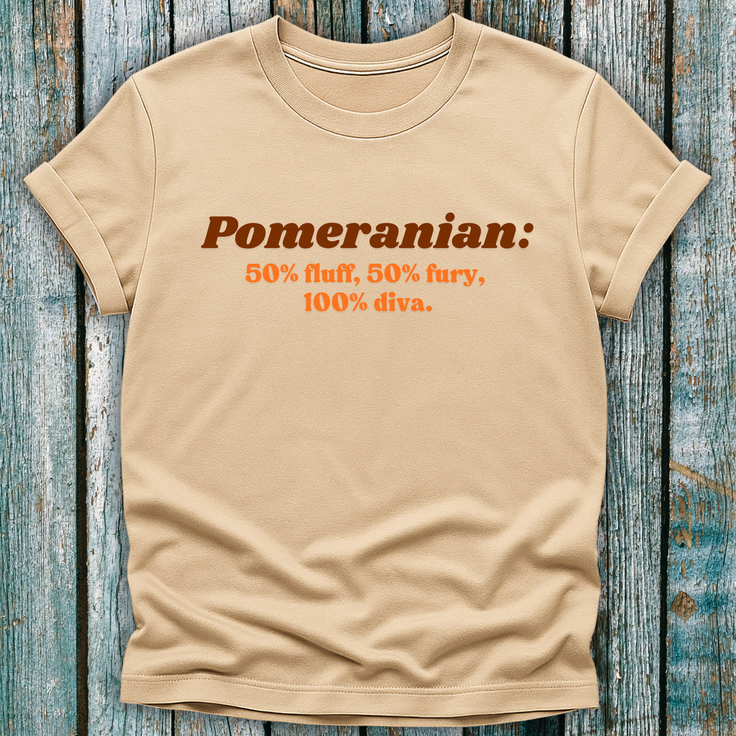 Beige Pomeranian lover t-shirt withbrown text on a wooden surface