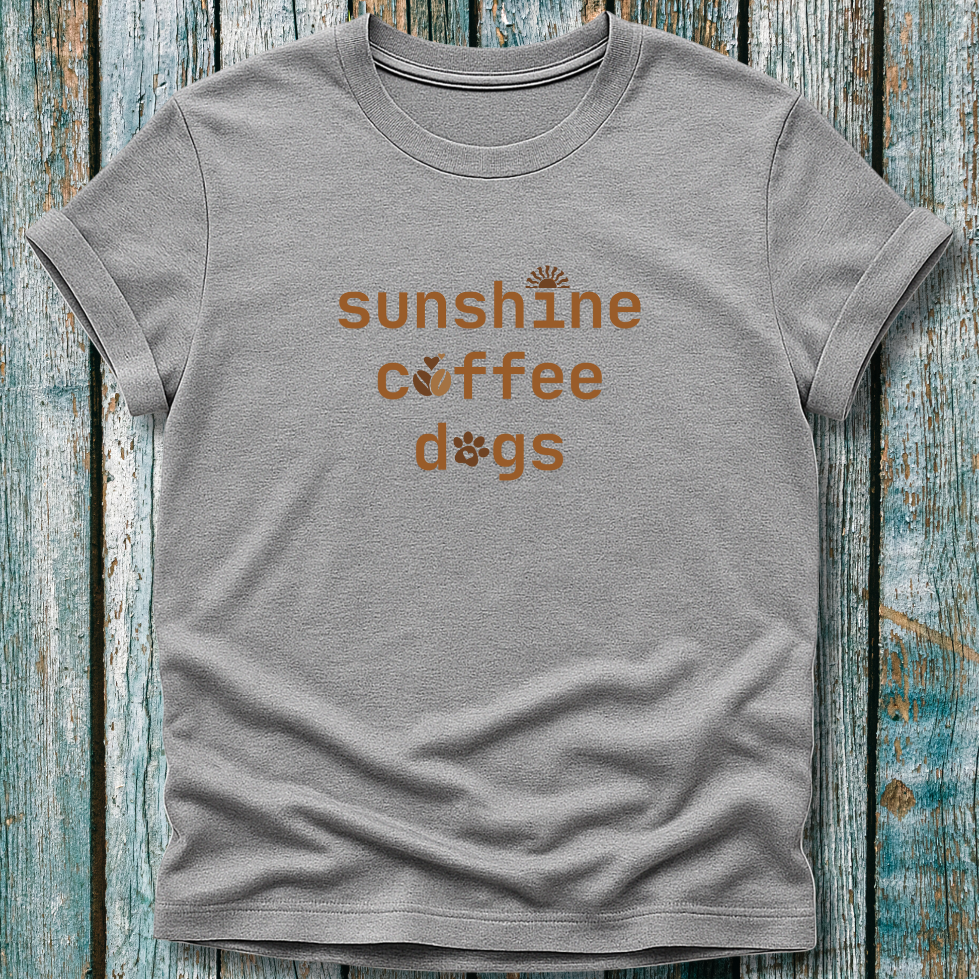 Gray t-shirt with 'sunshine coffee dogs' text on a wooden surface