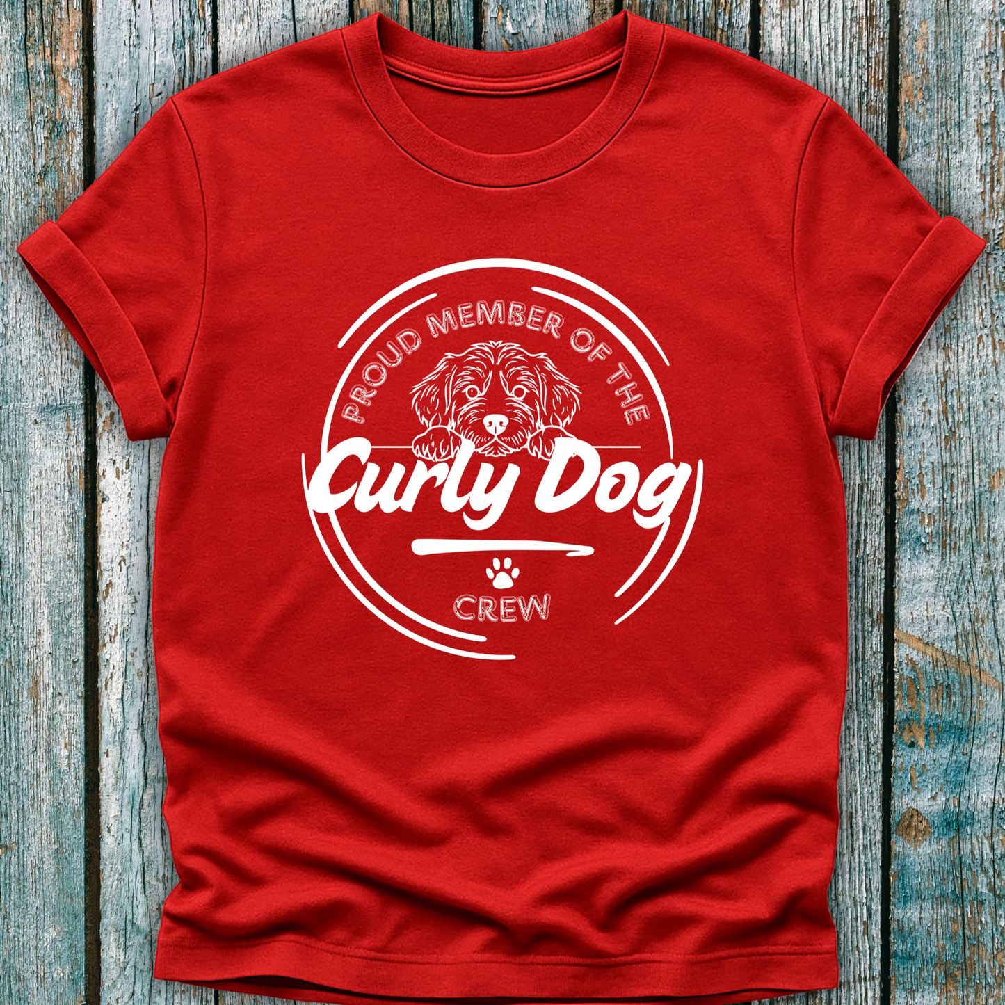Red t-shirt with 'Proud Member of the Curly Dog Crew' design on a wooden surface