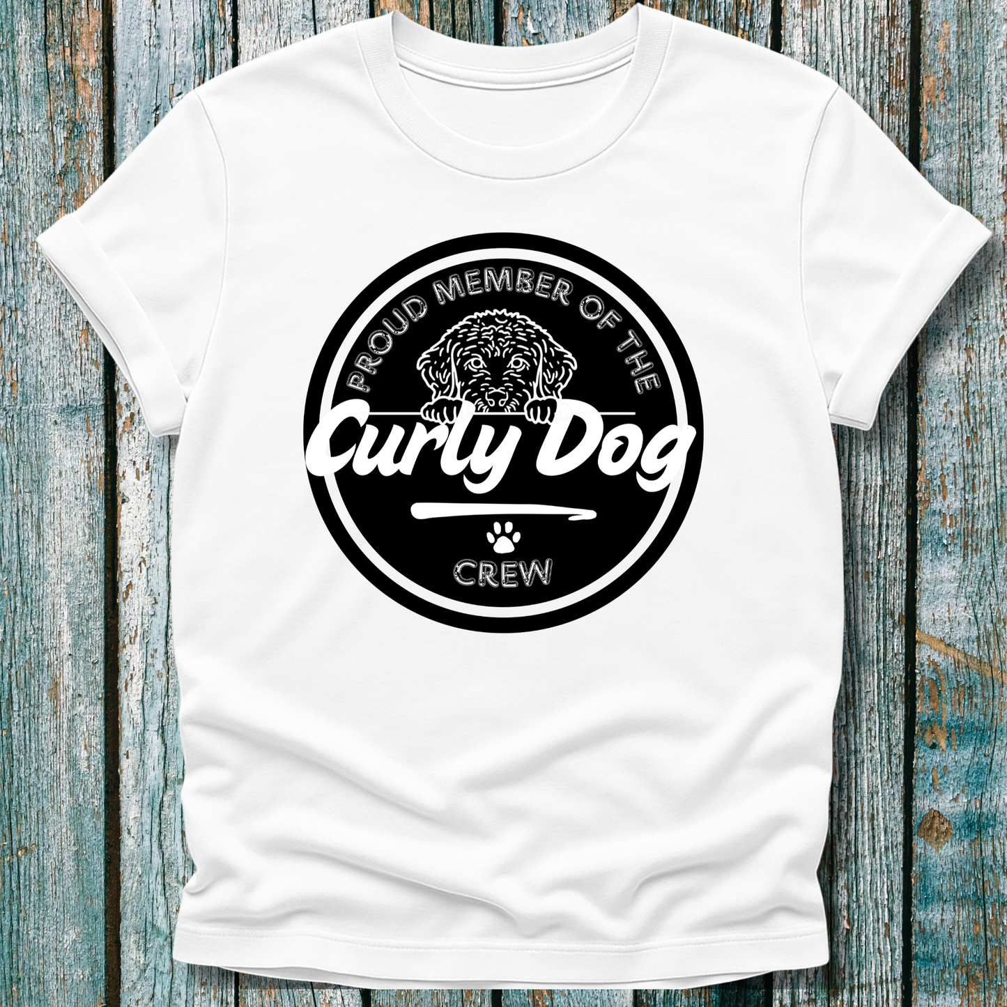 White t-shirt with 'Proud Member of the Curly Dog Crew' graphic on a wooden surface