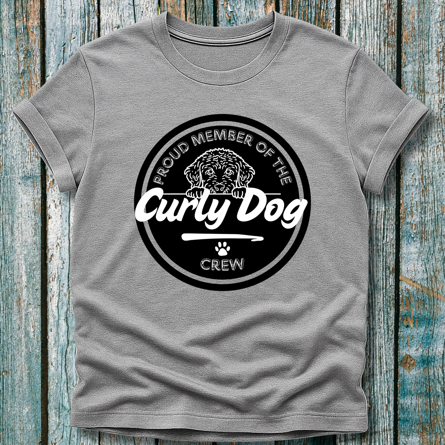 Gray t-shirt with 'Proud Member of the Curly Dog Crew' graphic on a wooden surface