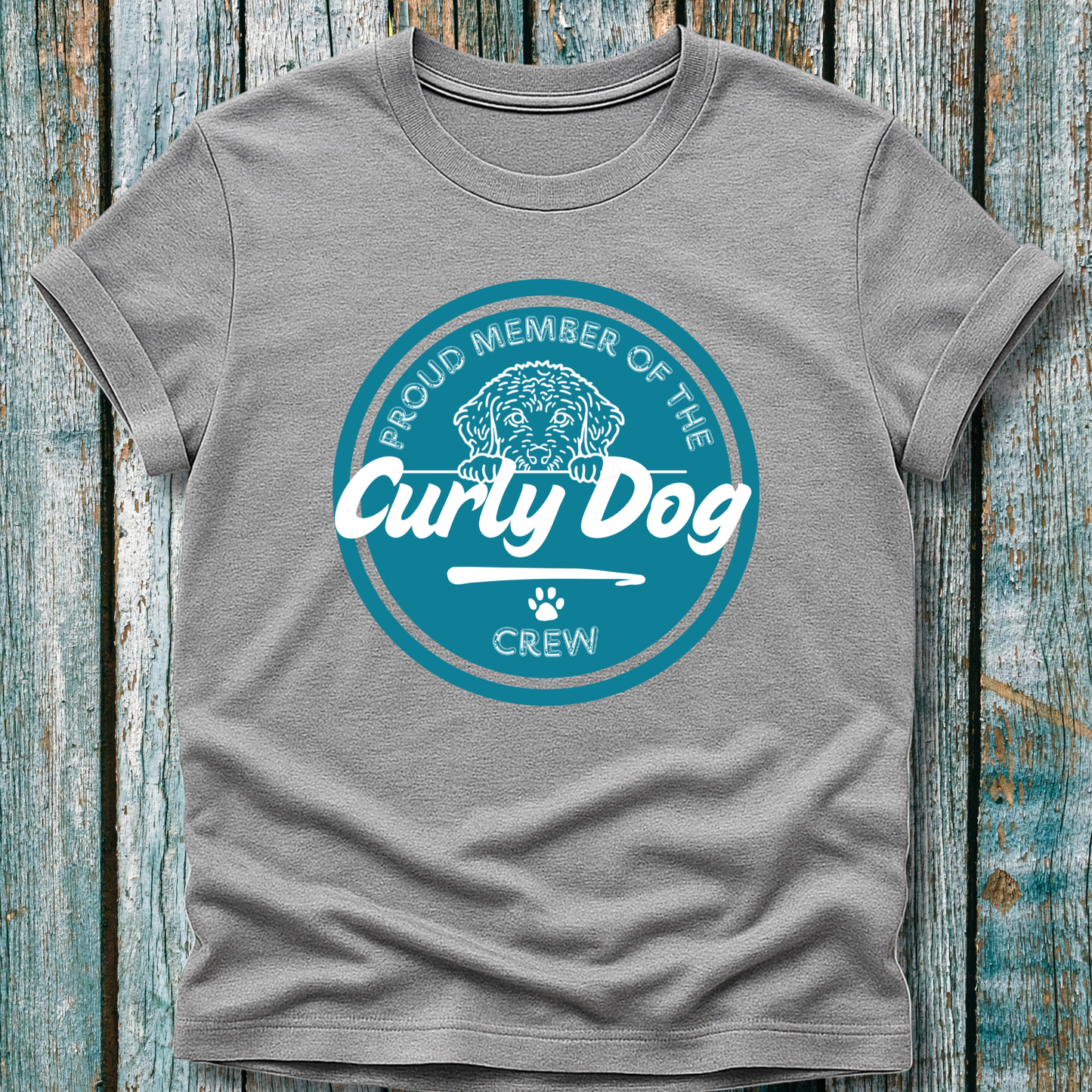 Gray t-shirt with 'Proud Member of the Curly Dog Crew' design on a wooden background