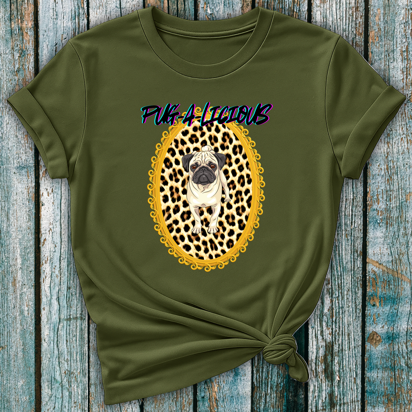 Green t-shirt with a pug in a leopard print frame and 'Pug-A-Licious' text on a wooden surface