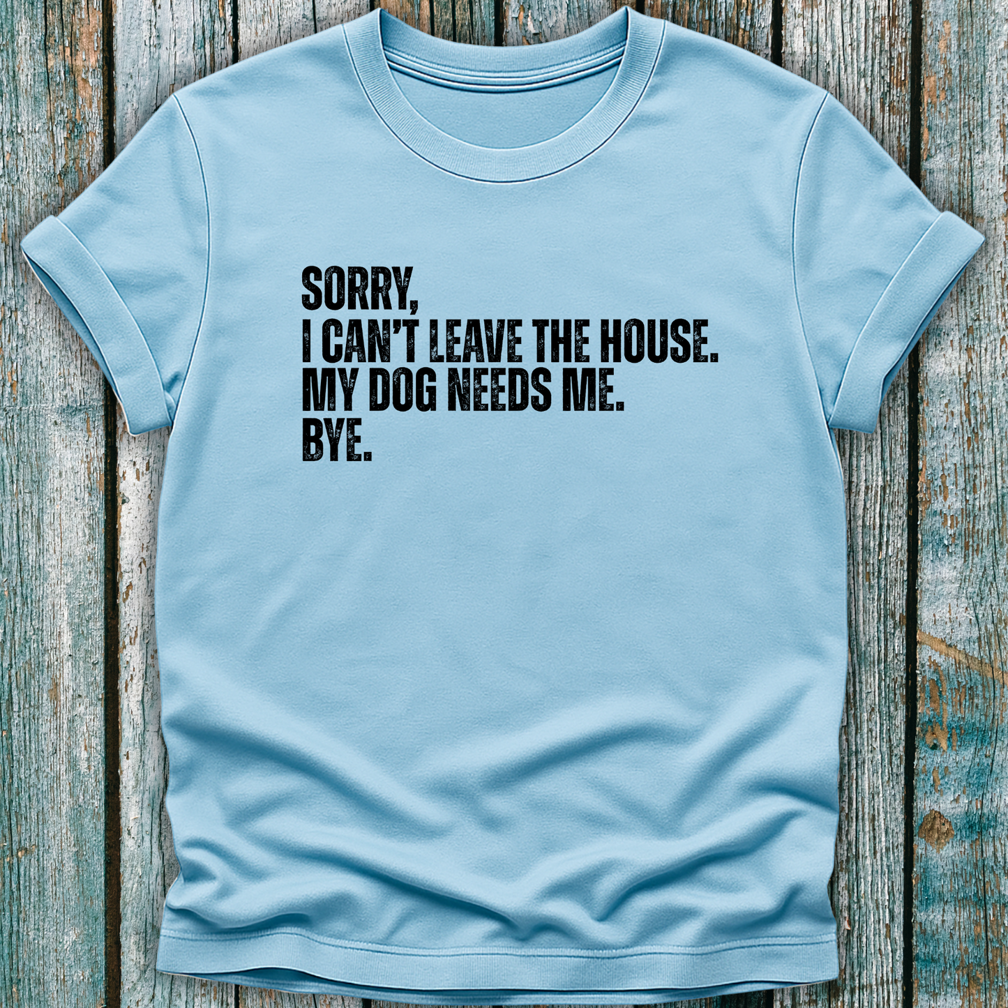 Light blue T-shirt with Sorry, I can't leave the house. My dog needs me. Bye.