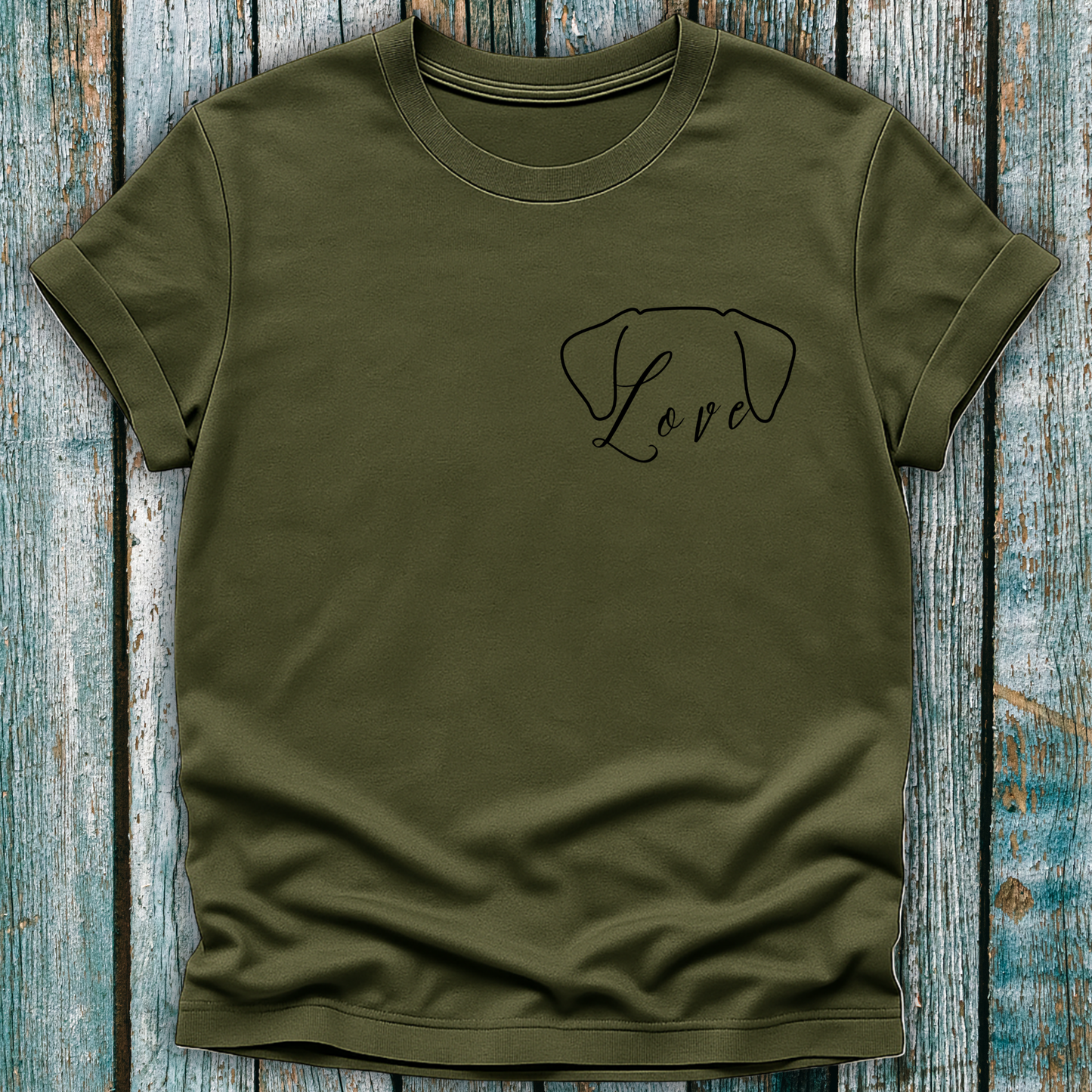 Green t-shirt with 'Love' and a dog ears design on a wooden surface
