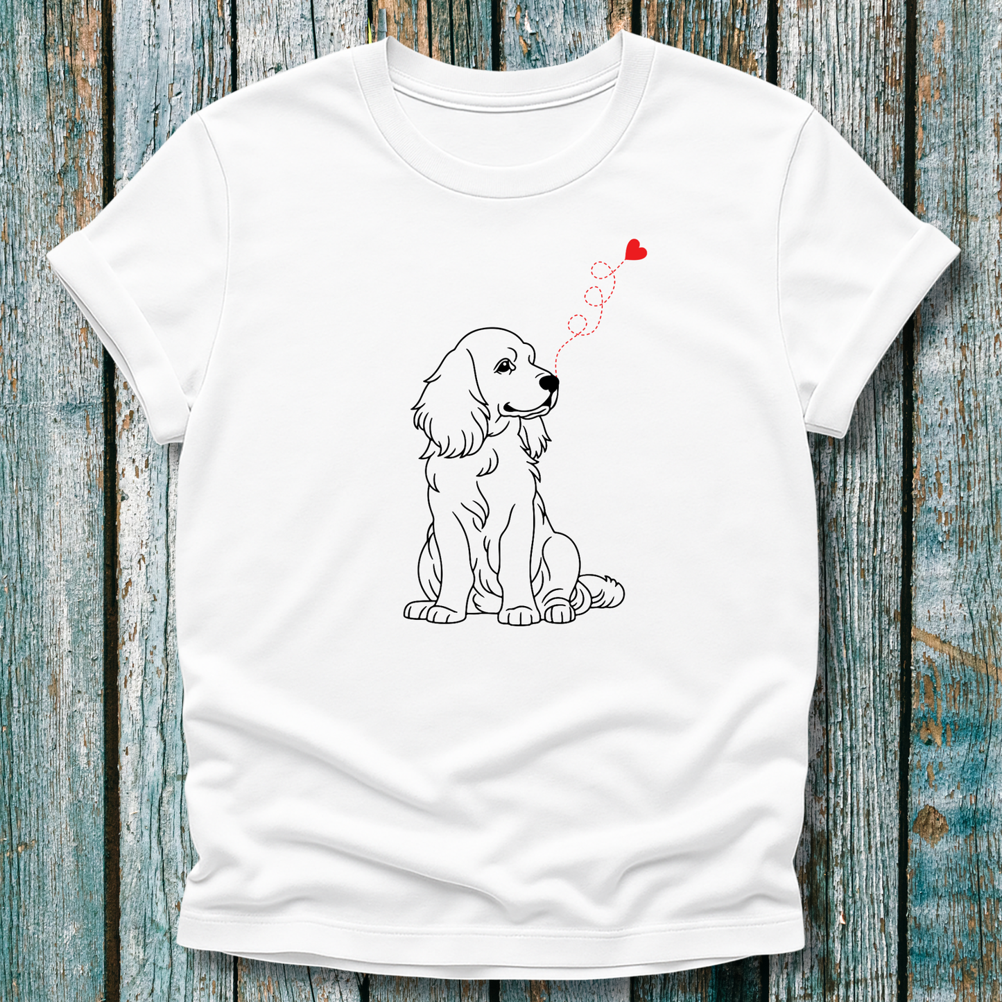 White t-shirt with a dog illustration and heart-shape on a wooden surface