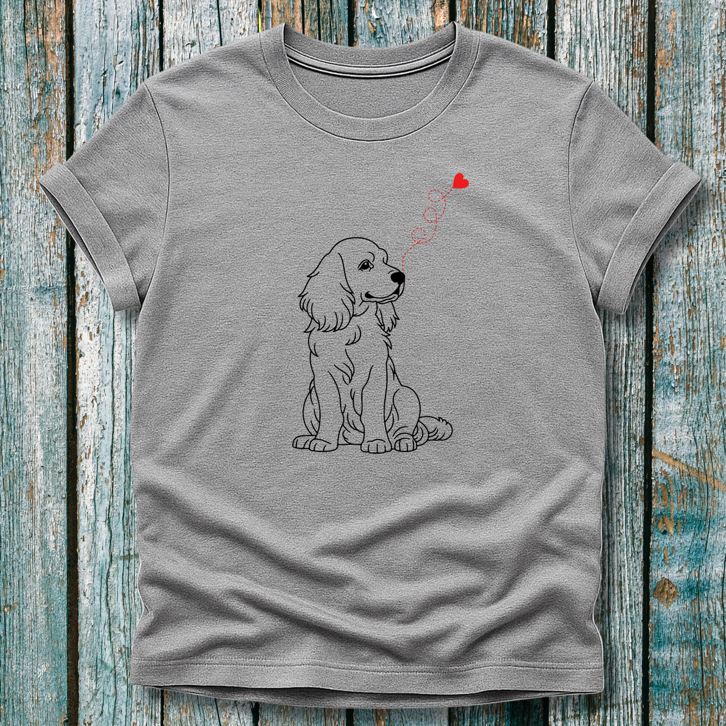Gray t-shirt with a dog graphic and heart-shap on a wooden surface