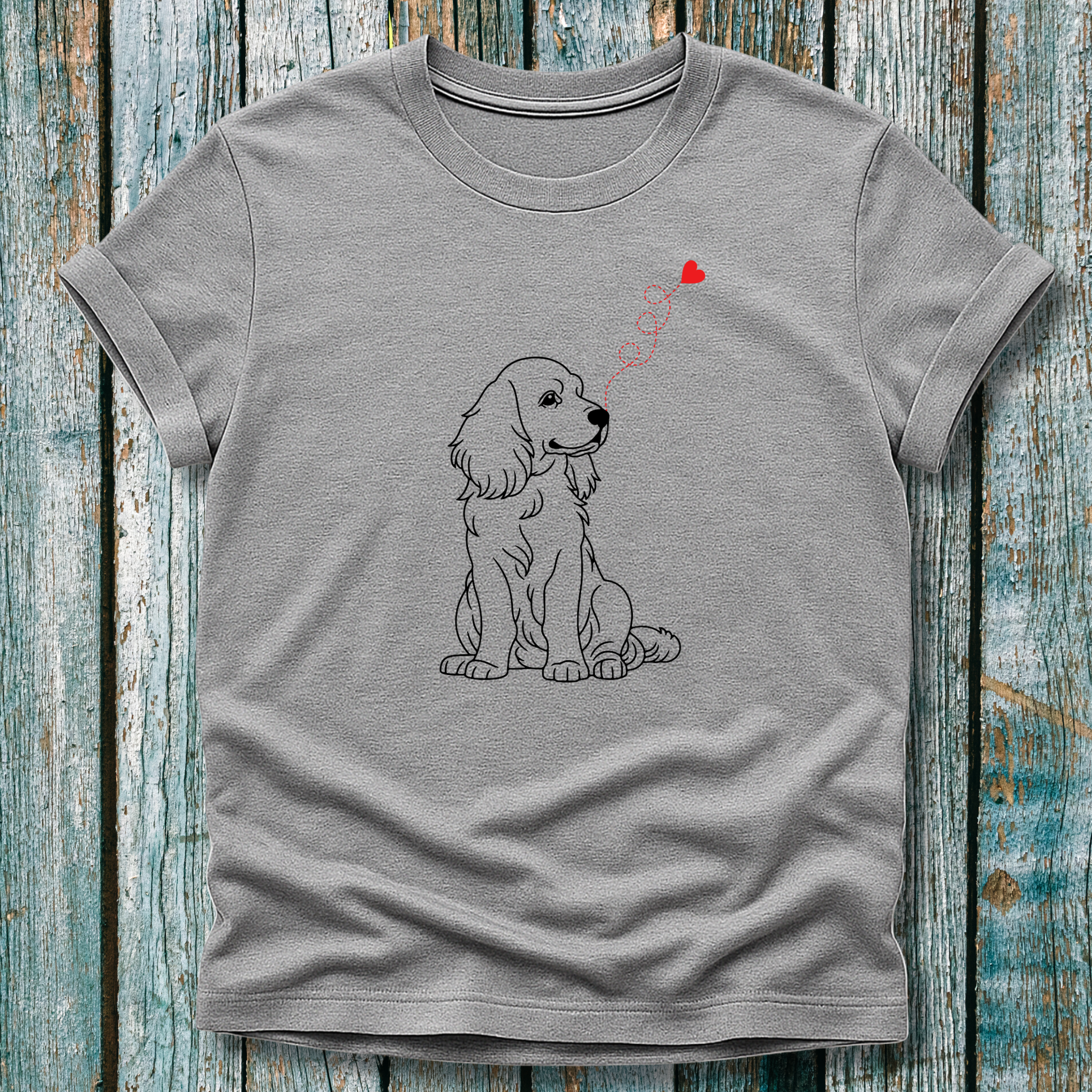 Gray t-shirt with a dog graphic and heart-shap on a wooden surface