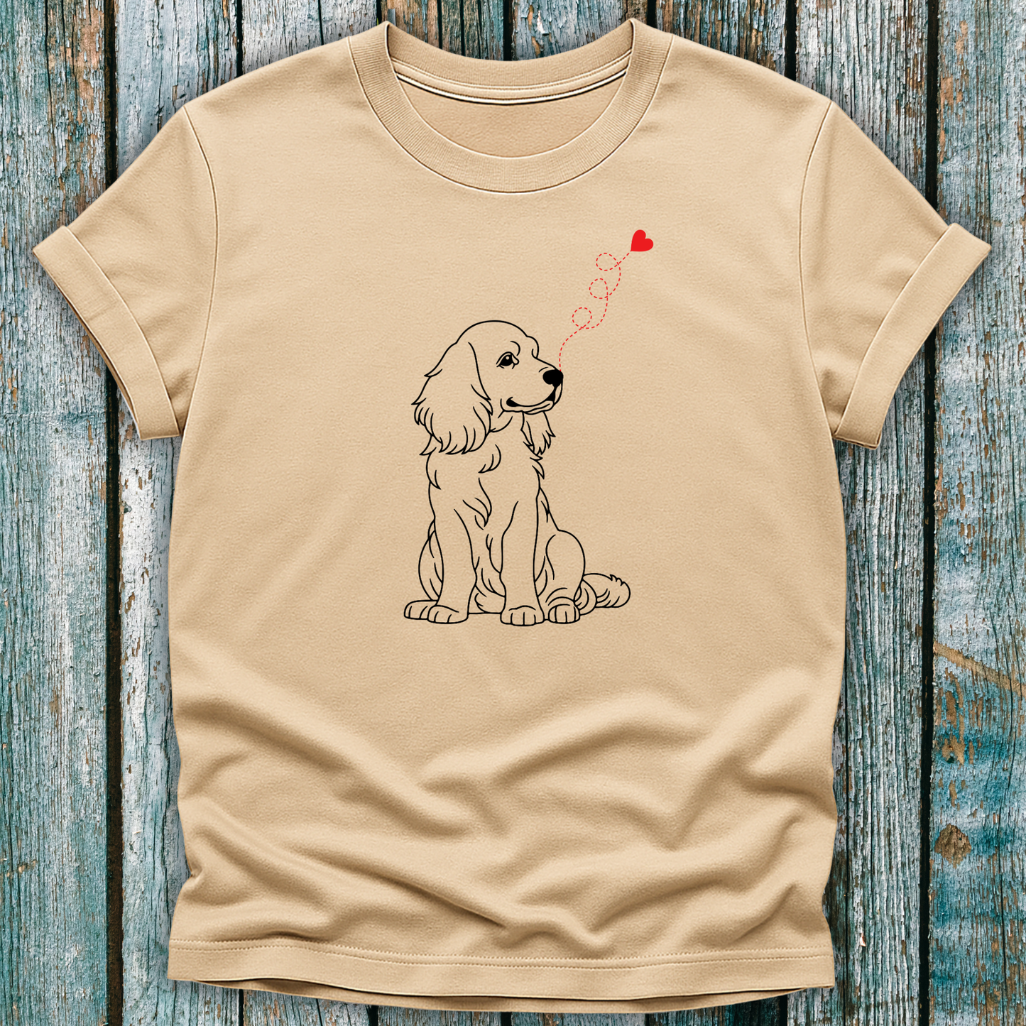 Beige t-shirt with a dog and heart design on a wooden surface