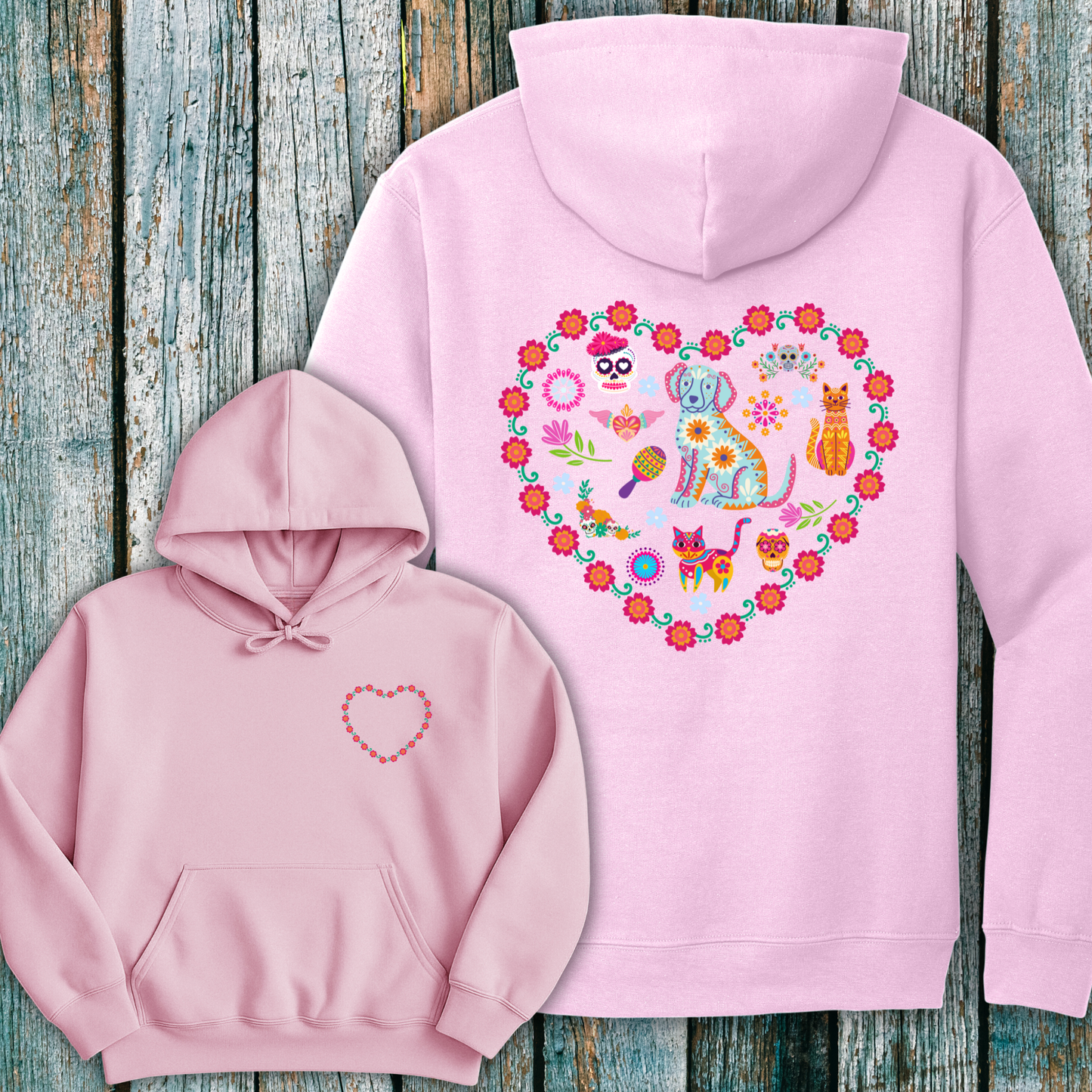 Pink hoodie with day of the dead inspired heart design on the front and  back against a wooden background.
