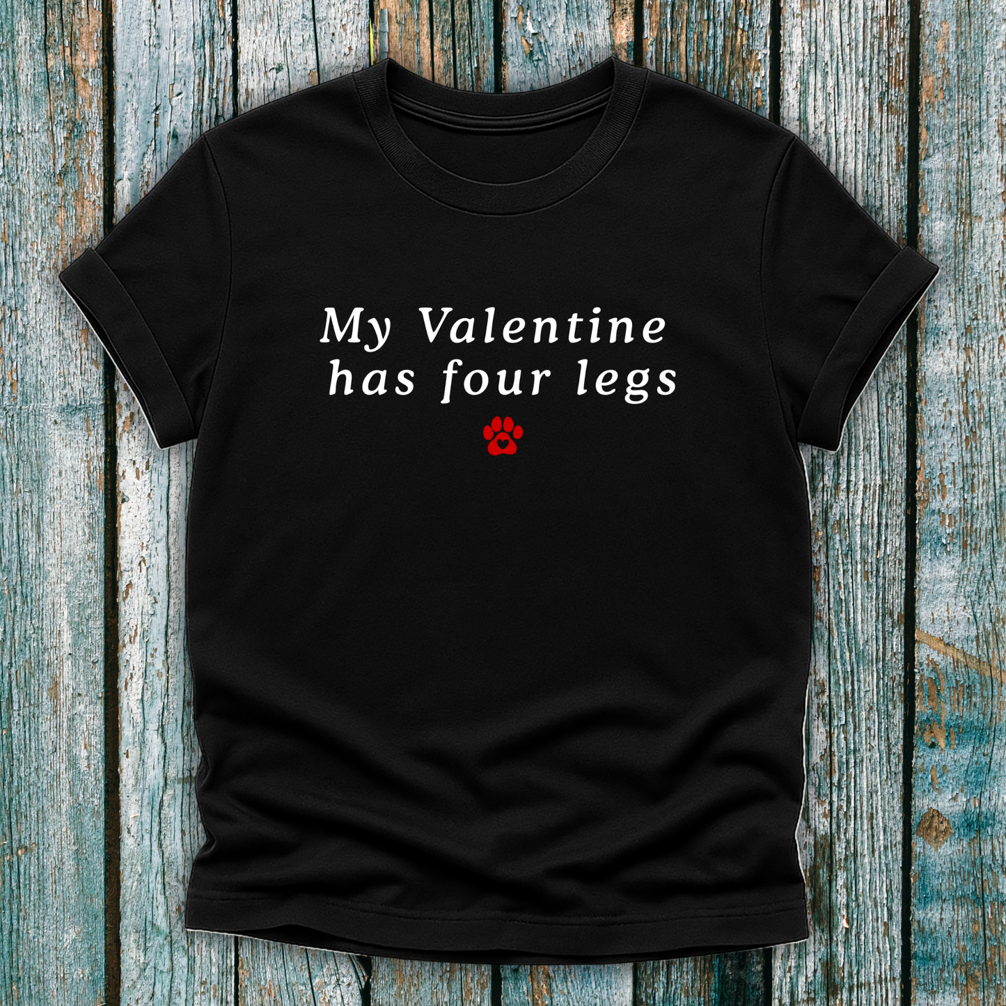 Black t-shirt with 'My Valentine has four legs' text on a wooden surface