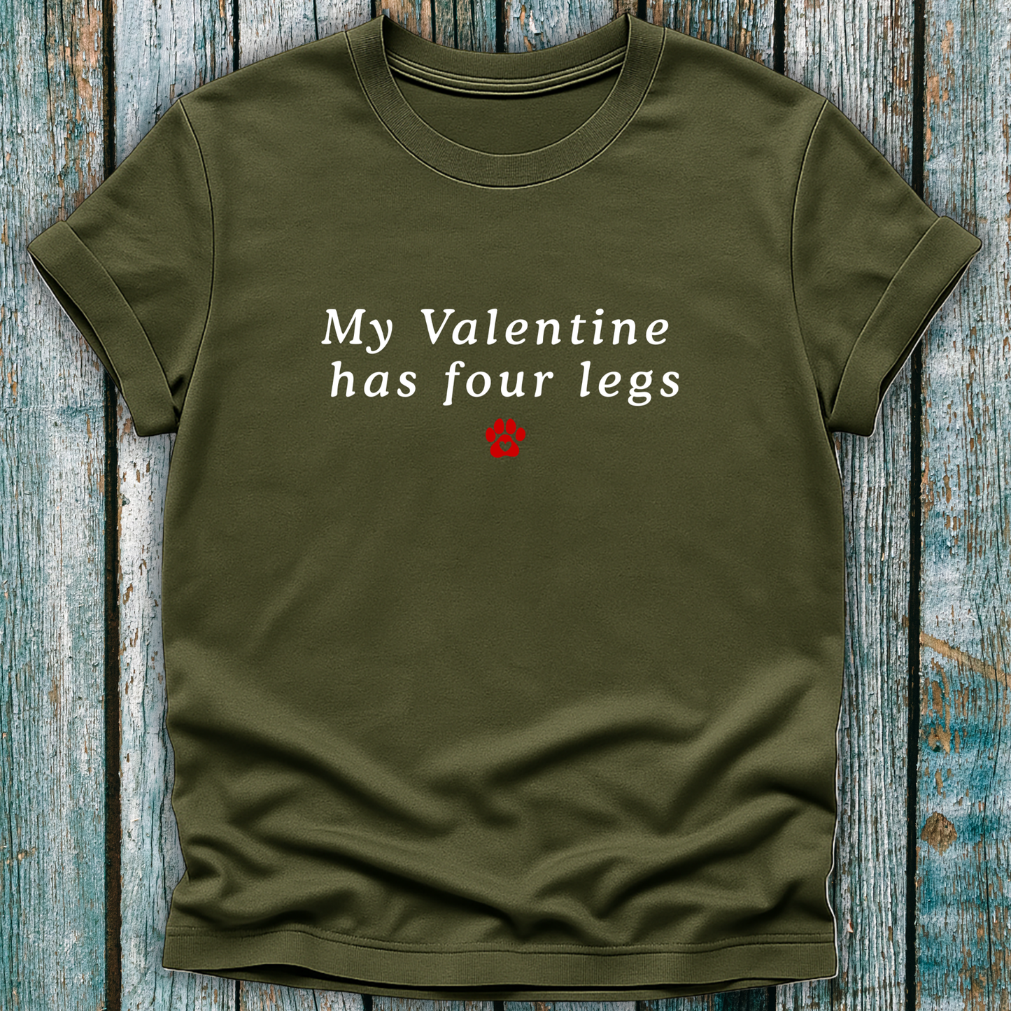 Green t-shirt with 'My Valentine has four legs' text on a wooden surface