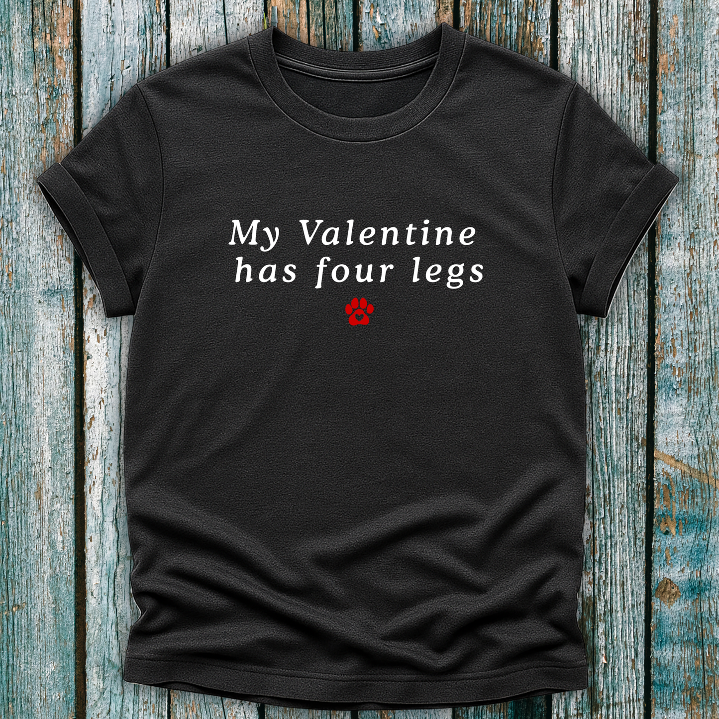 Black t-shirt with 'My Valentine has four legs' text on a wooden surface