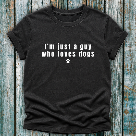 Black t-shirt with 'I'm just a guy who loves dogs' text on a wooden surface