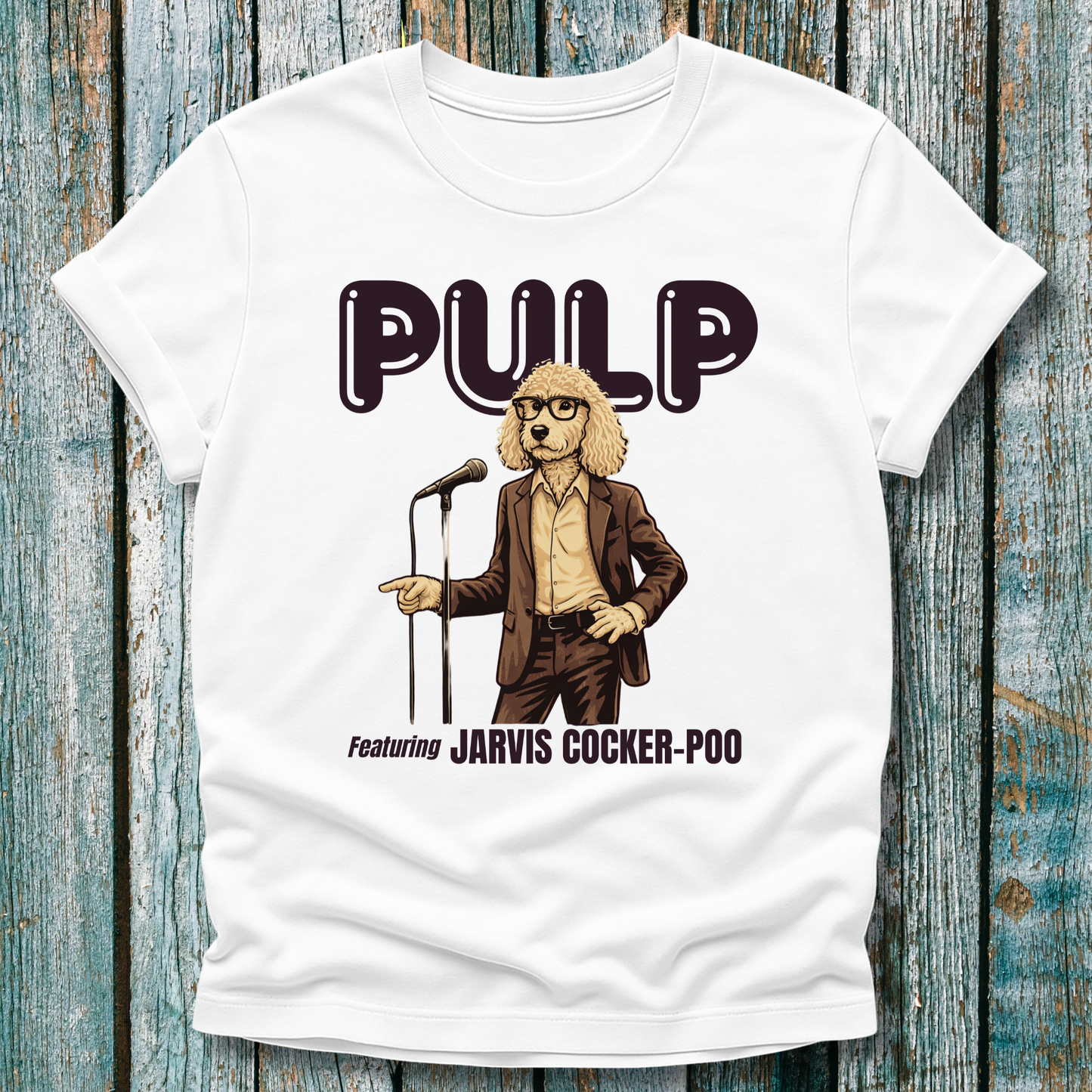 White t-shirt with a graphic of a dog in a suit and glasses holding a microphone, labeled 'Pulp featuring Jarvis Cocker-Poo' on a wooden background.