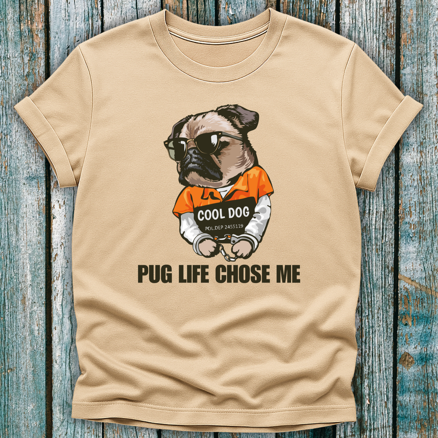 Beige t-shirt with a pug graphic and text on a wooden surface