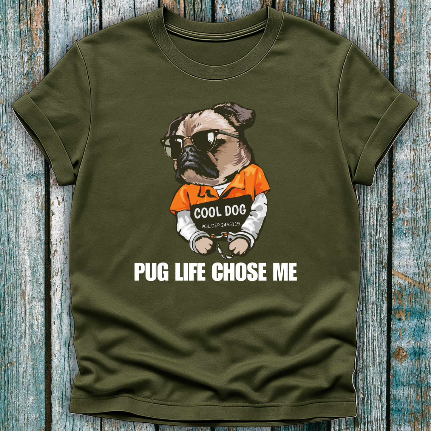 Green t-shirt with a pug graphic and text on a wooden surface