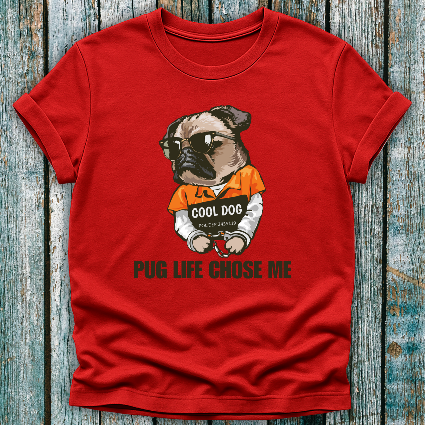 Red t-shirt with a graphic of a pug wearing sunglasses and an 'Cool Dog' shirt, text 'Pug Life Chose Me' on a wooden surface.