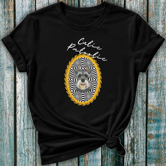 Black t-shirt with a Schnauzer illustration and 'Cutie Patootie' text on a wooden surface