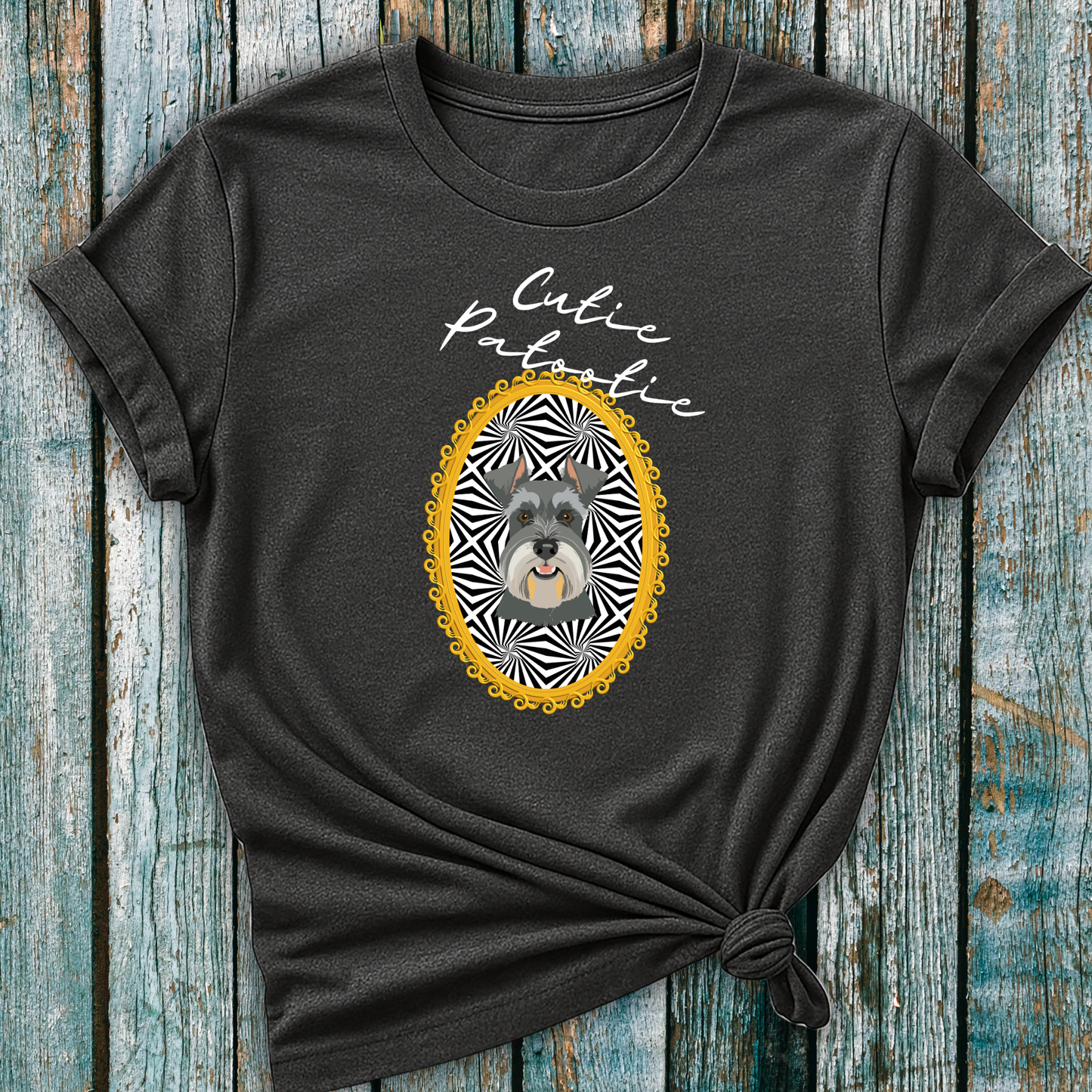 Gray t-shirt with a Schnauzer illustration and 'Cutie Patootie' text on a wooden surface