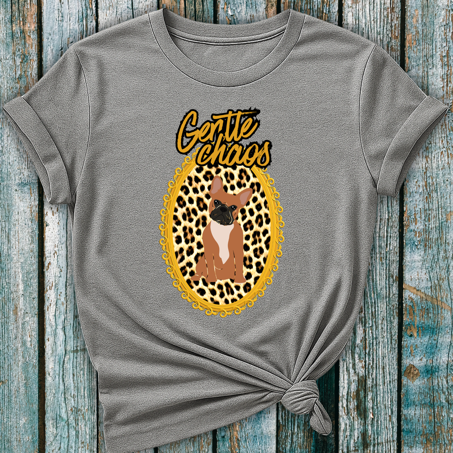 Gray t-shirt with a graphic of a Frenchie dog in a leopard print frame and 'Gentle Chaos' text, on a wooden surface.