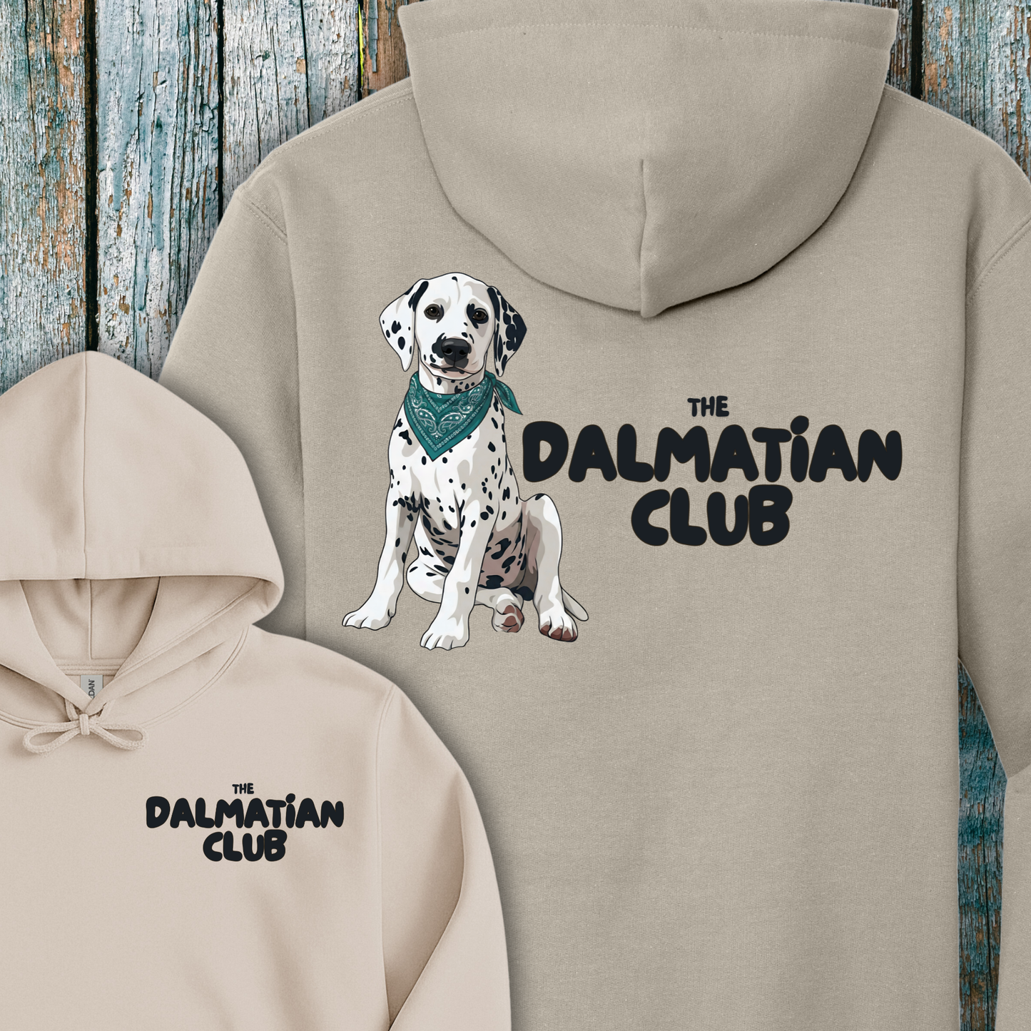 Beige hoodie with Dalmatian illustration and 'The Dalmatian Club' text on a wooden background