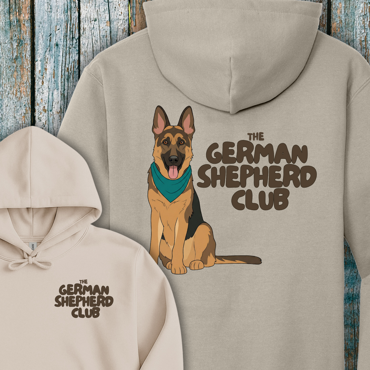 Beige hoodie with a German Shepherd design and 'The German Shepherd Club' text on a wooden background