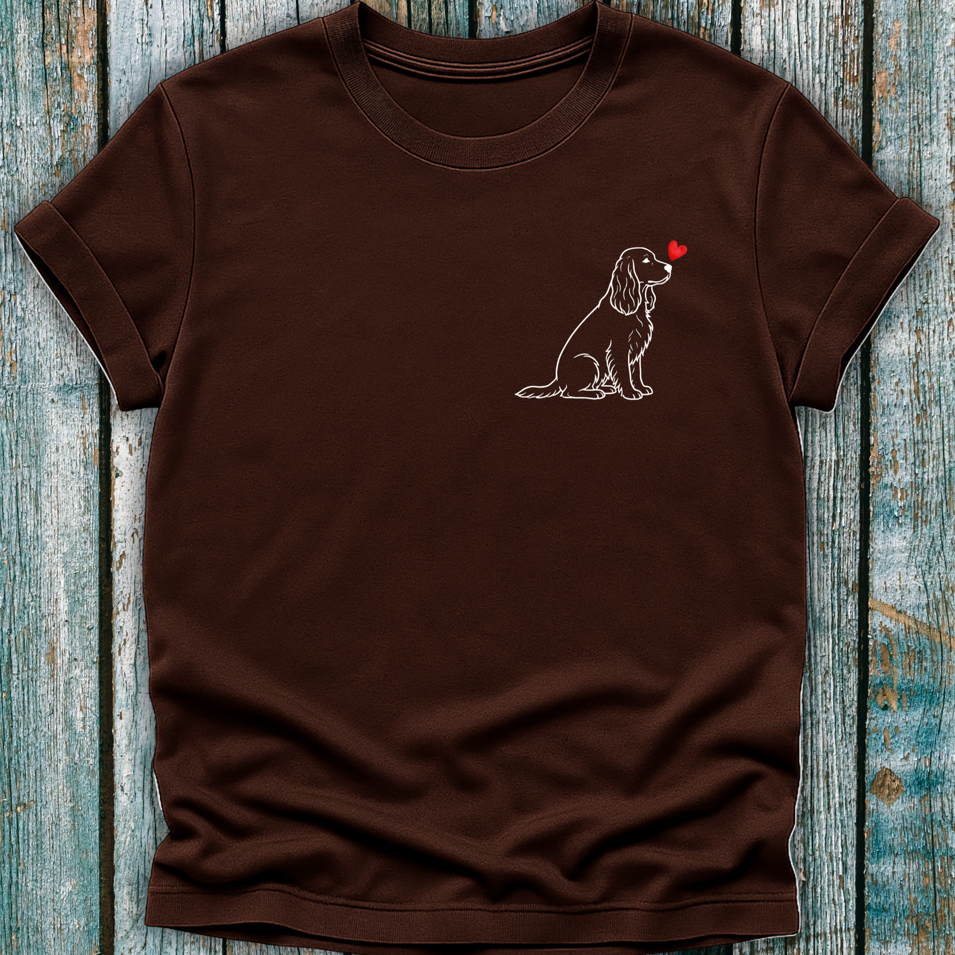 Brown t-shirt with a Spaniel dog illustration and red heart on a wooden surface