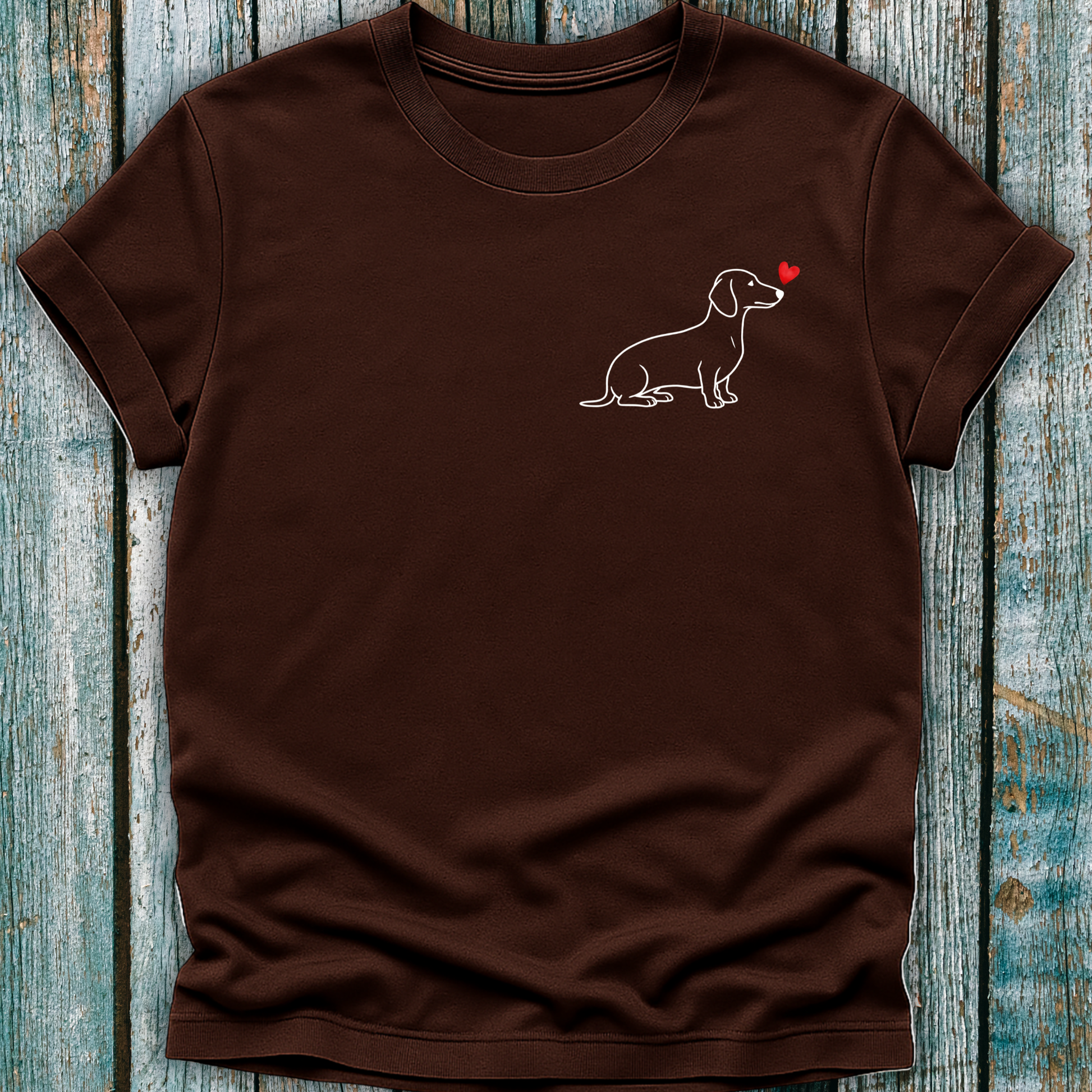 Brown t-shirt with a Dachshund dog illustration and red heart on a wooden surface