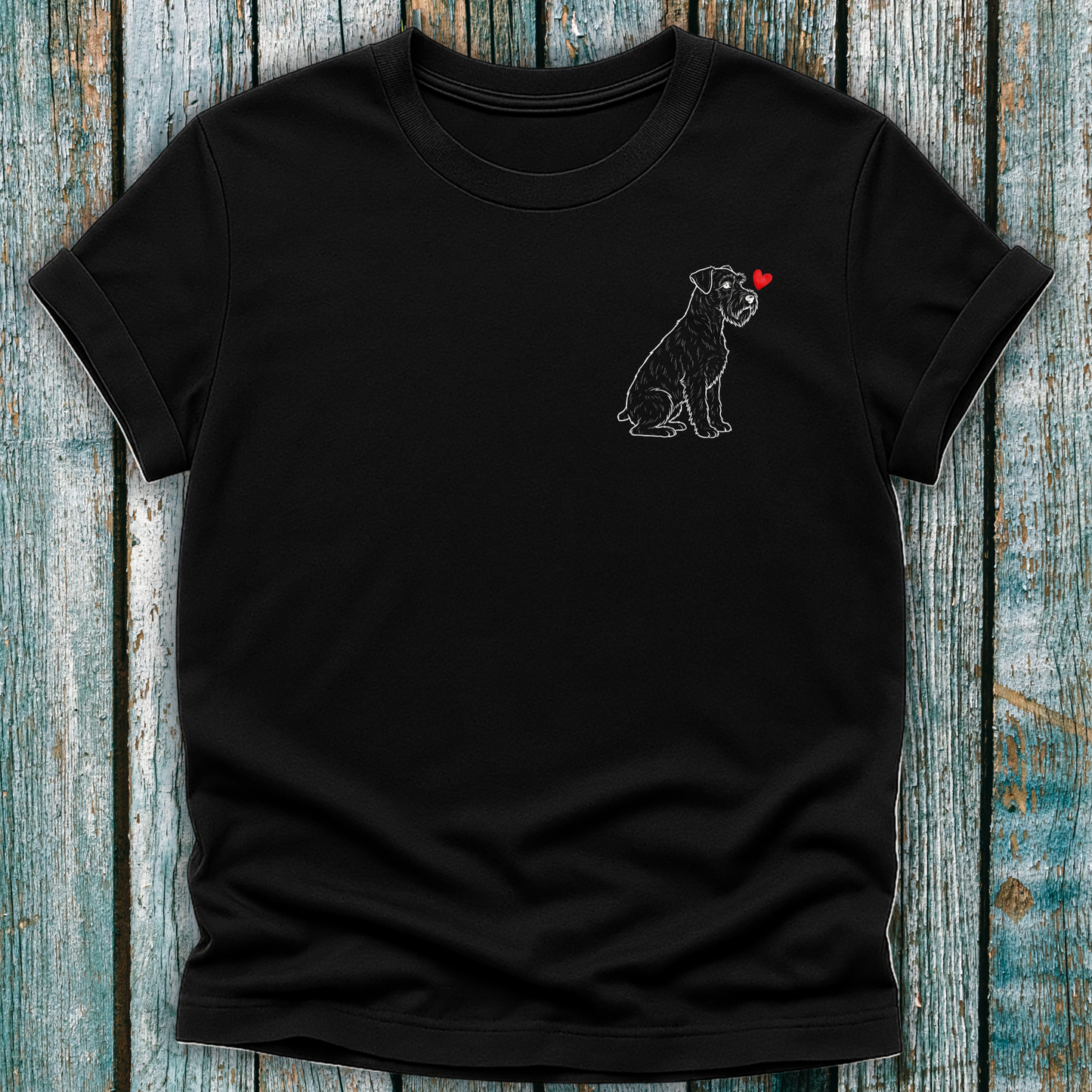 Black t-shirt with a Schnauzer dog graphic and red heart on a wooden surface