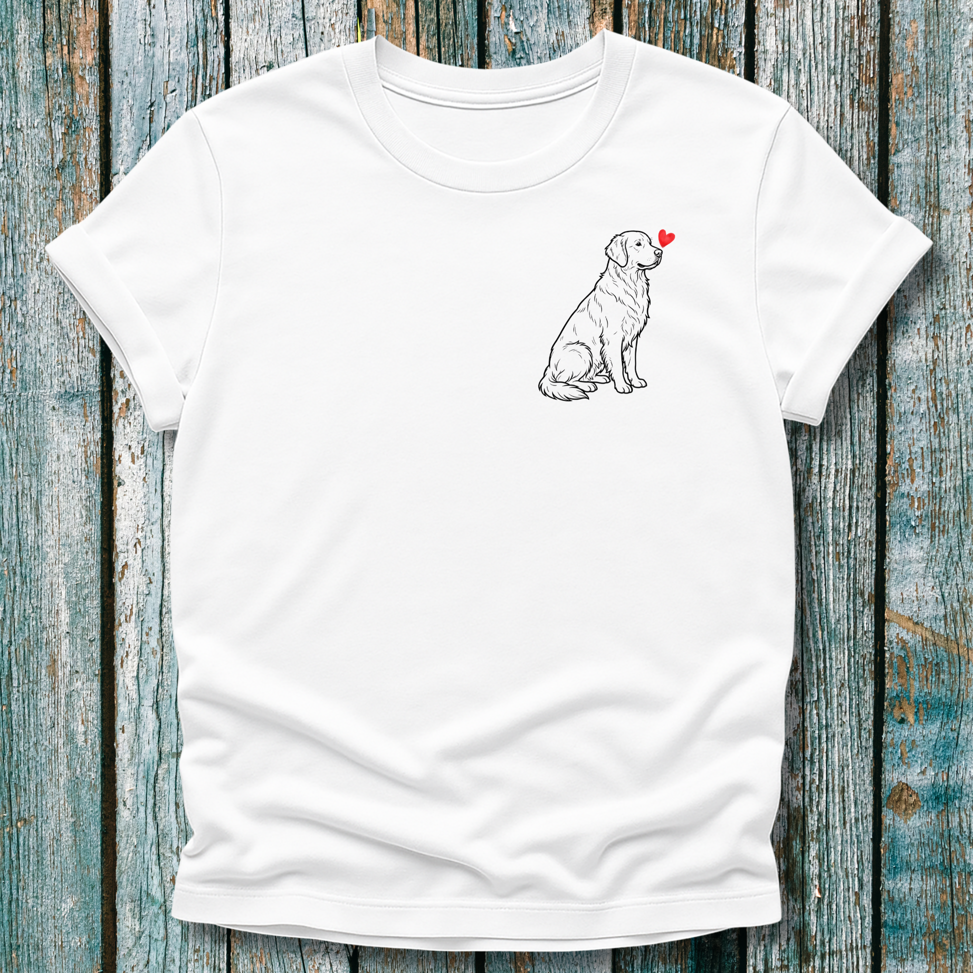 White t-shirt with a Golden Retriever dog illustration and red heart on a wooden surface