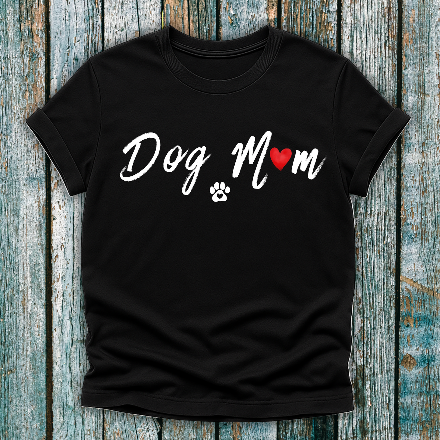 Black t-shirt with 'Dog Mom' 'Dog Mum' text and heart and paw graphic on a wooden surface