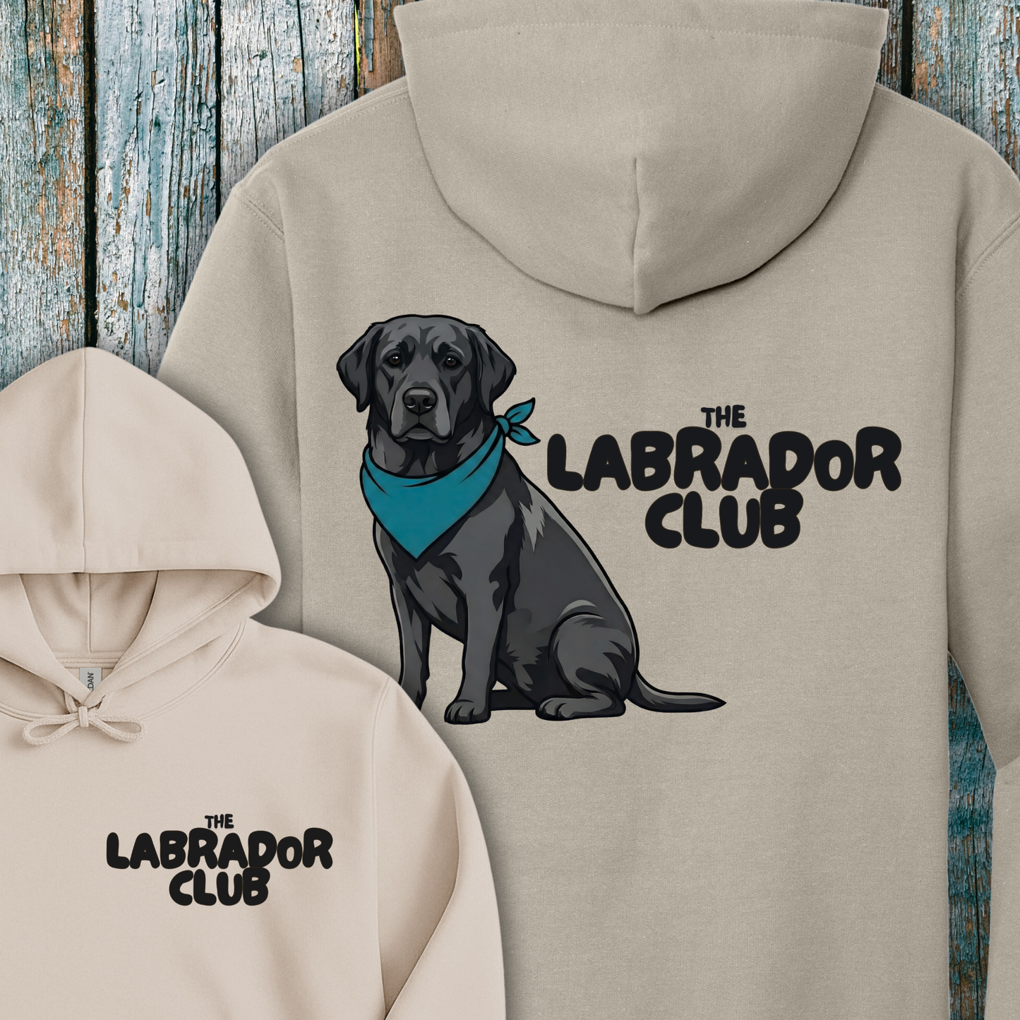 Beige hoodie with a black Labrador illustration and 'The Labrador Club' text on a wooden background