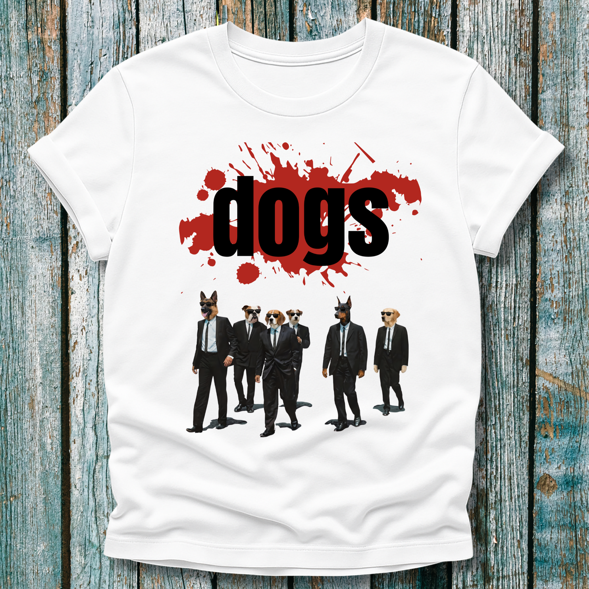 White t-shirt with graphic design of dogs in suits and 'dogs' text on a wooden surface