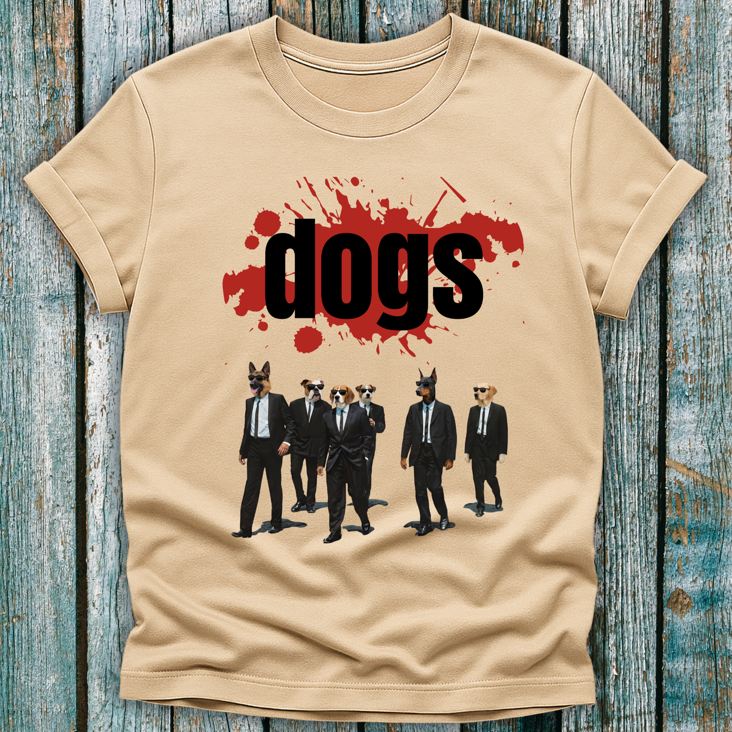 Beige t-shirt with graphic design of dogs in suits and 'dogs' text on a wooden surface