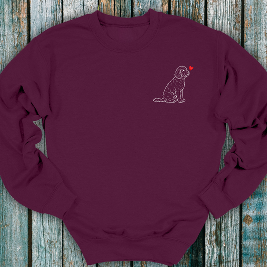 Maroon sweatshirt with a Cockapoo dog and heart design on a wooden surface
