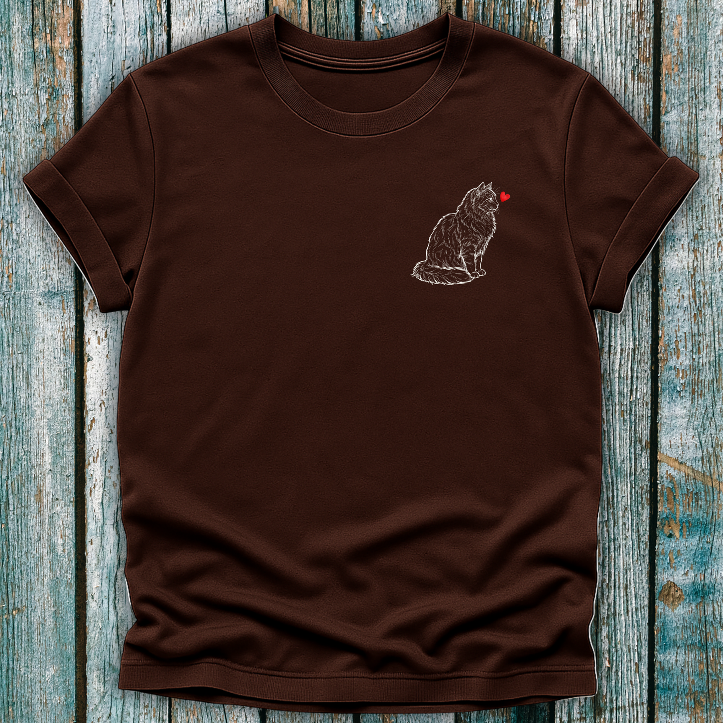 Brown  t-shirt with a cat graphic and red heart on a wooden surface