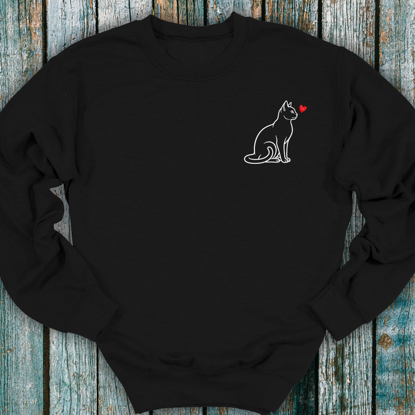 Black sweatshirt with a cat and heart design on a wooden surface