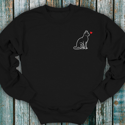 Black sweatshirt with a cat and heart design on a wooden surface