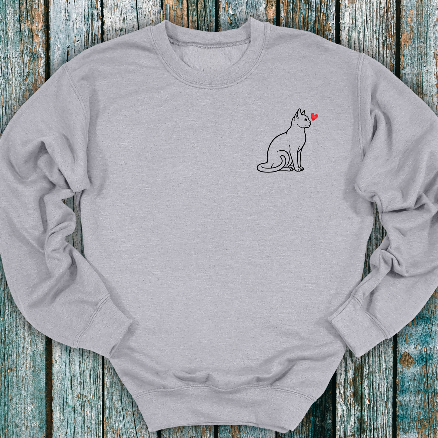 Gray sweatshirt with a cat and heart design on a wooden surface