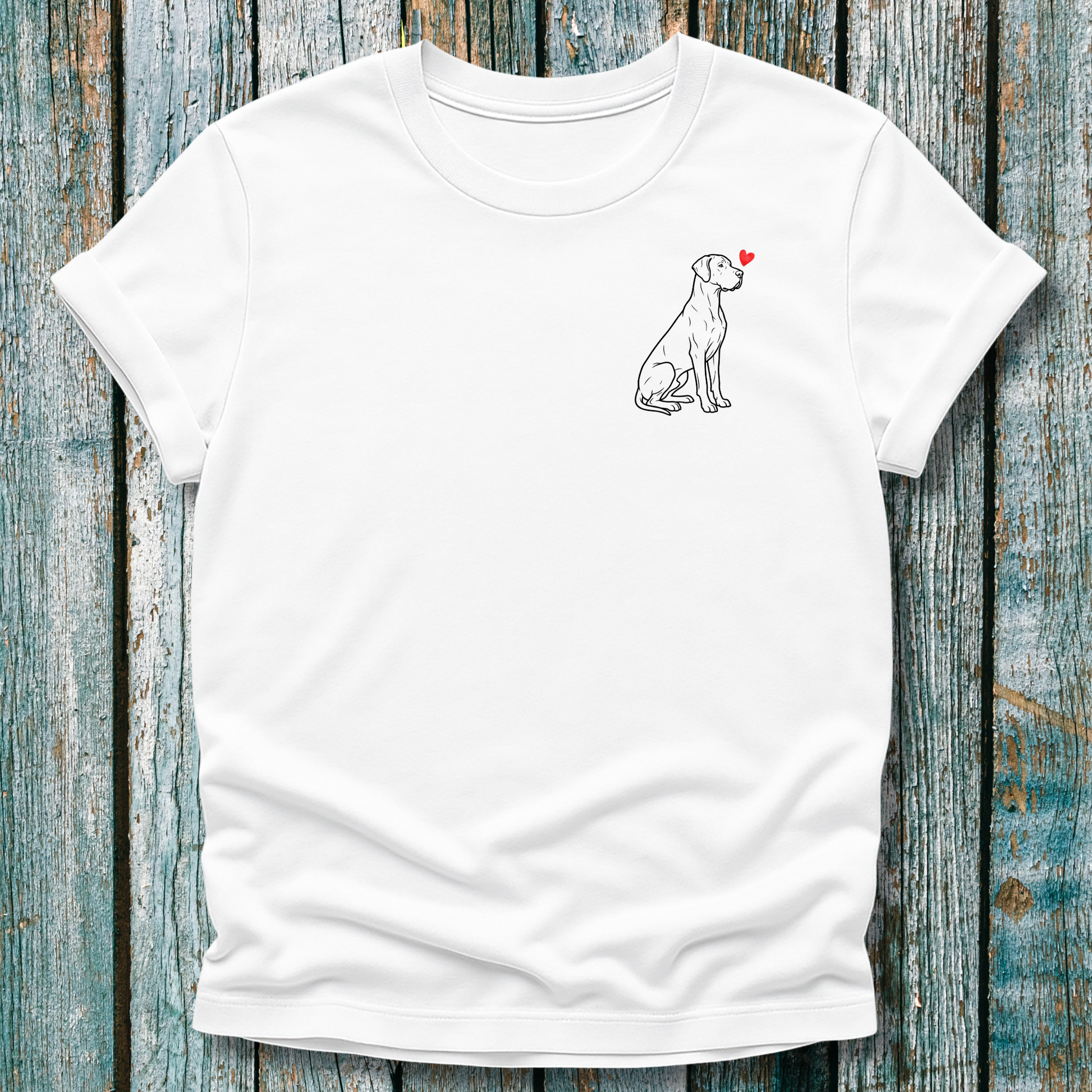 White t-shirt with a Great Dane dog illustration with a red heart on a wooden surface