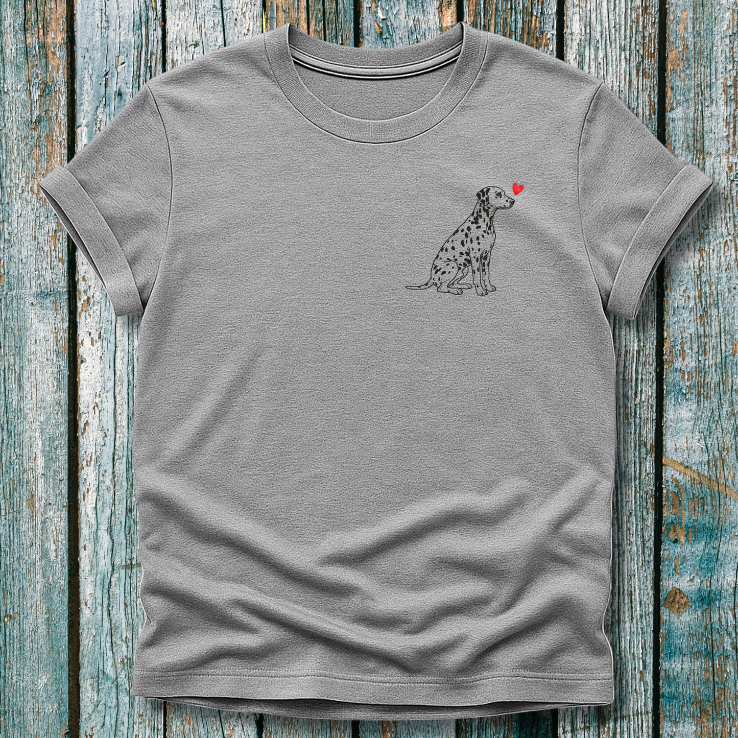 Gray t-shirt with a Dalmatian dog illustration and a red heart on a wooden surface