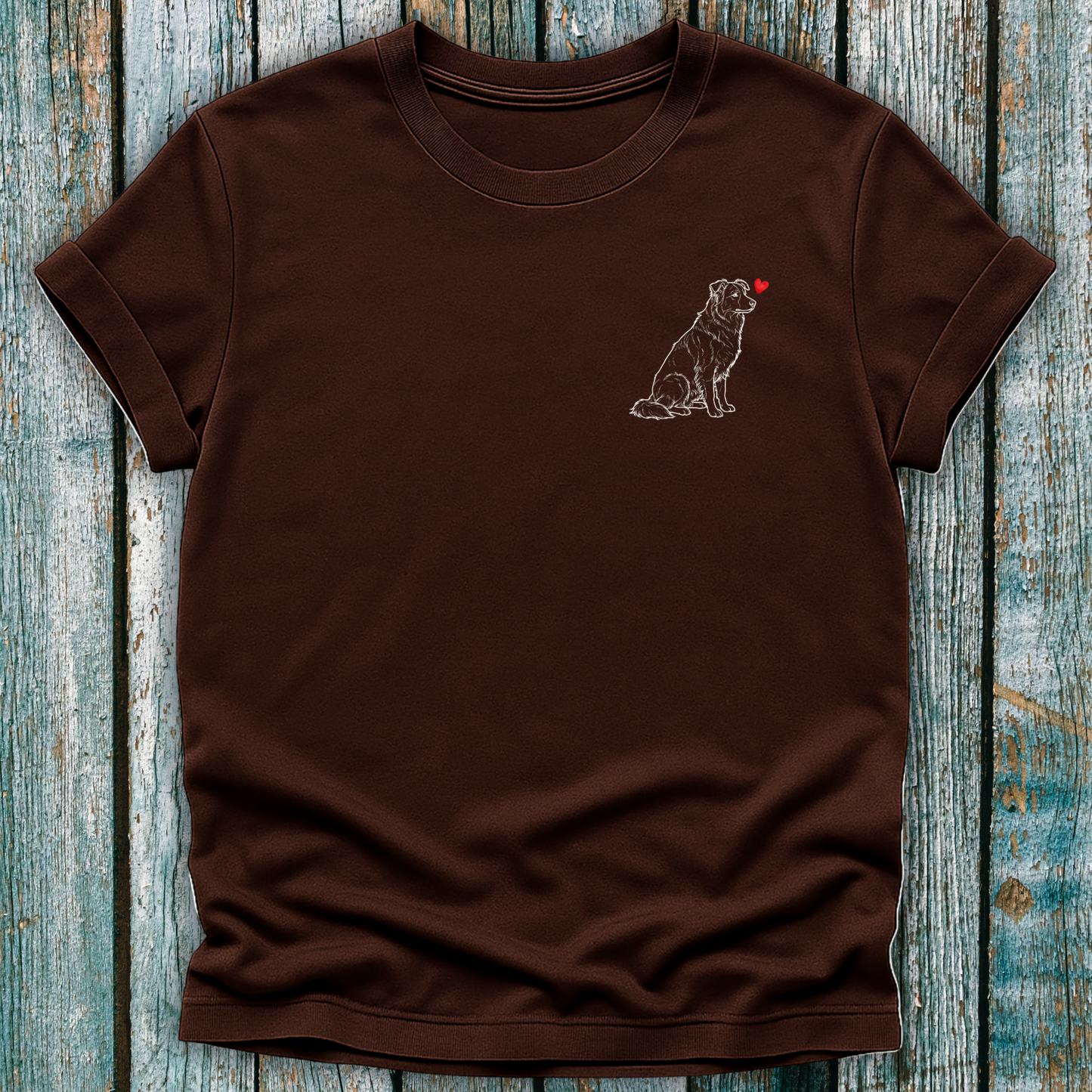 Brown  t-shirt with a Greyhound dog graphic and a red heart on a wooden surface