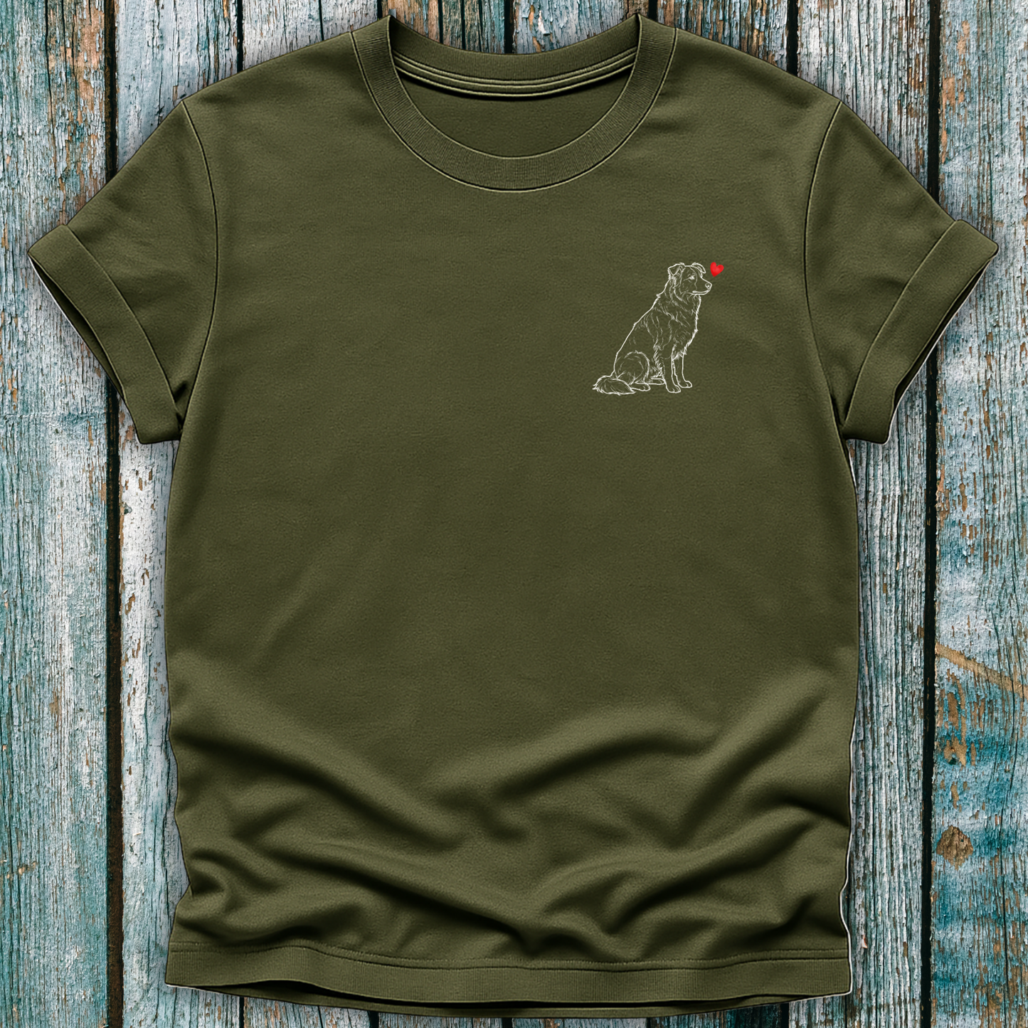 Green  t-shirt with a Greyhound dog graphic and a red heart on a wooden surface