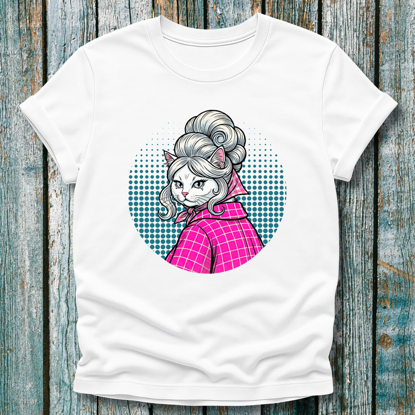 White  t-shirt with a colorful graphic of a pop art cat character in a pink outfit on a wooden surface